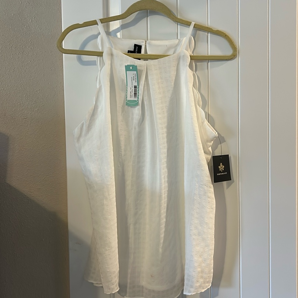 Cream sleeveless top with scalloped arm hole.